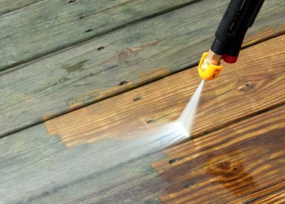 Power washing equipment cleaning an exterior surface